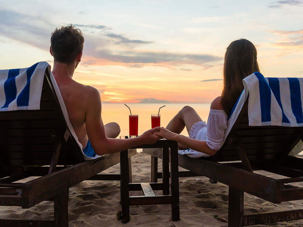 Couple on beach chairs with some beverages