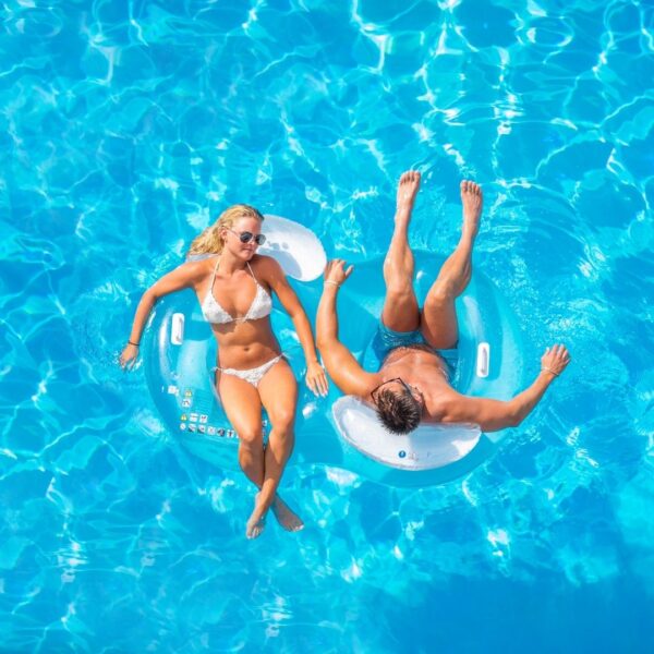 A male and female floating in a pool
